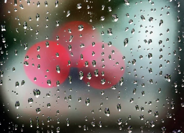 Gotas de lluvia en la ventana con luces bokeh — Foto de Stock