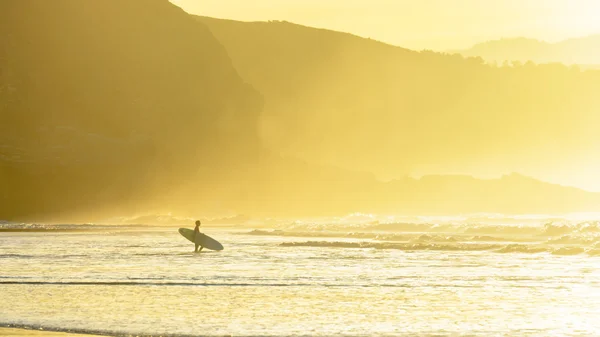 Surfeur entrant dans l'eau au coucher du soleil — Photo