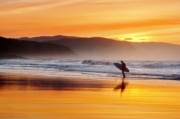 Surfeur quittant l'eau au coucher du soleil — Photo