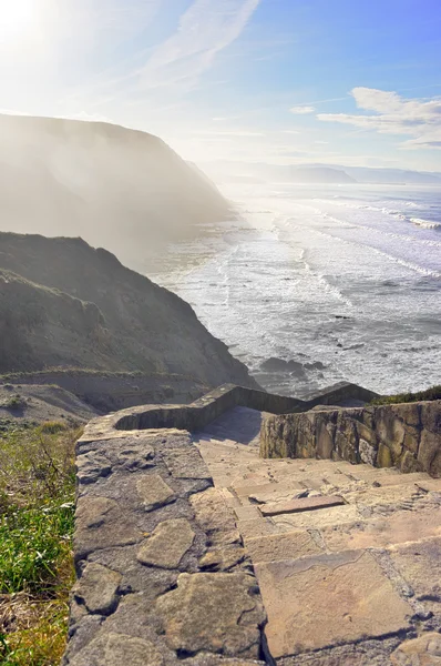 Stone stairs to rocky beach with waves — Stock Photo, Image