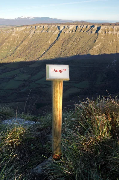 Pfosten mit Gefahrenschild auf Bergklippe — Stockfoto