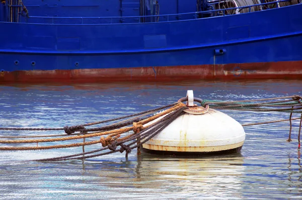 Rusty buoy with lot of ropes and a ship — Stock Photo, Image