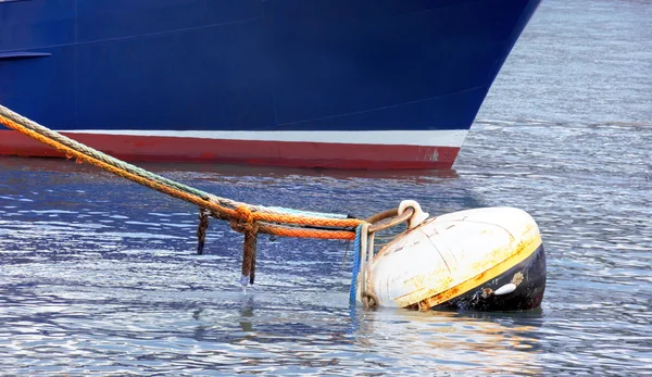 Rusty buoy with lot of ropes and a ship — Stock Photo, Image