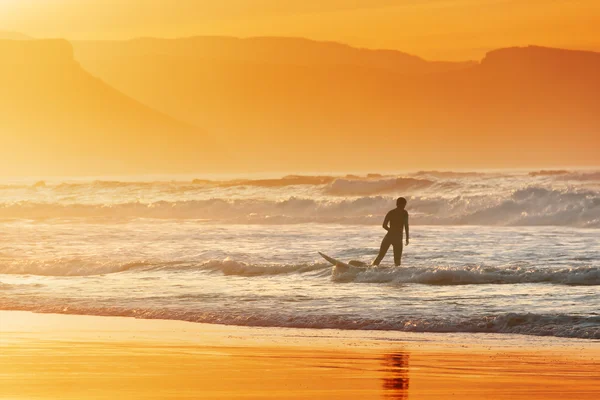 Surfeur sortant de l'eau au coucher du soleil — Photo