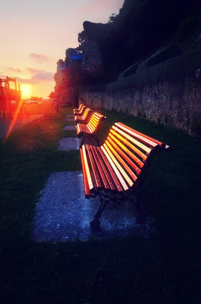 Benches at sunset reflecting sunlight — Stock Photo, Image