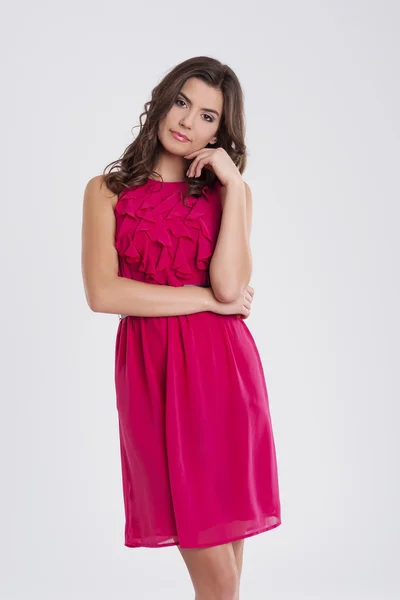 Young beautiful brunette in a pink dress — Stock Photo, Image