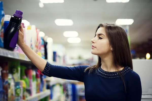 Женщина выбирает моющее средство в супермаркете — стоковое фото