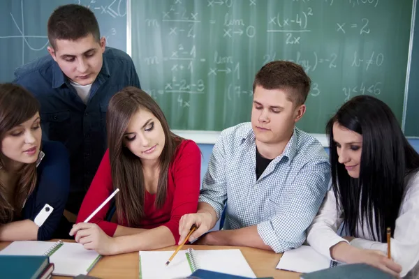 Grupo de estudiantes trabajando juntos en el aula —  Fotos de Stock