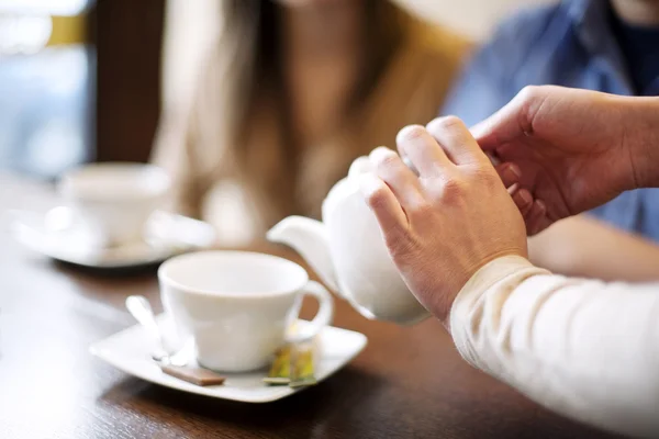 Официантка наливает чашку кофе или чая — стоковое фото