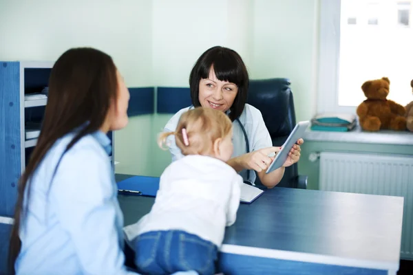 Médico mostrando los resultados médicos de la madre en la tableta — Foto de Stock