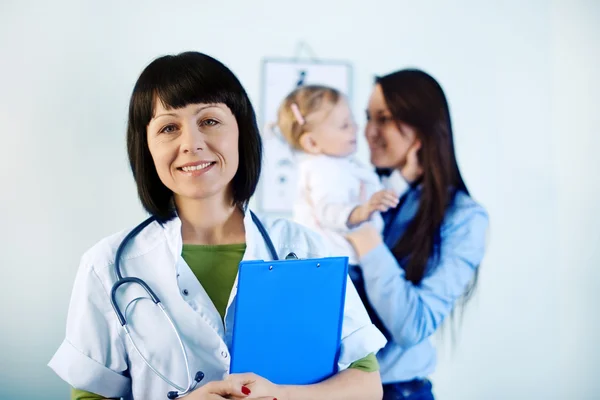 Smiling doctor holding notes — Stock Photo, Image