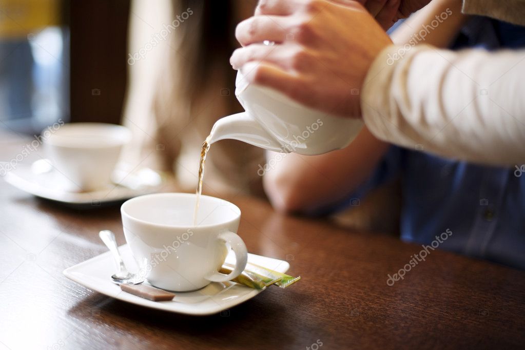 Waitress pouring cup of coffee or tea