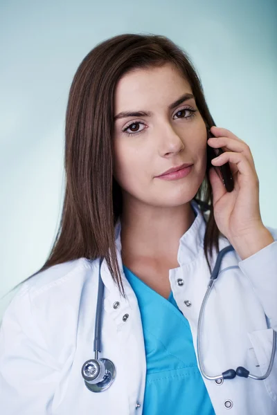 Unga kvinnliga läkare på telefon — Stockfoto