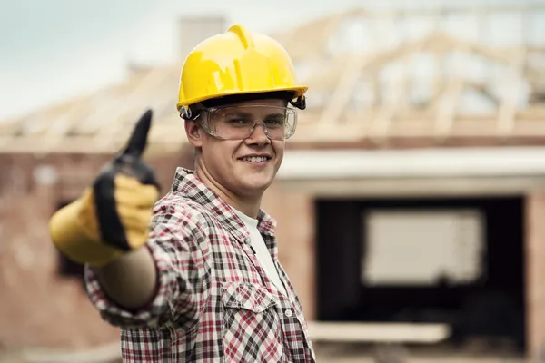 Bouw werknemer gebaren duimschroef opwaarts — Stockfoto