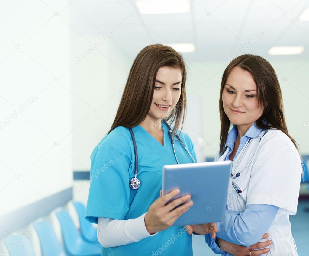 Female doctors checking results on digital tablet