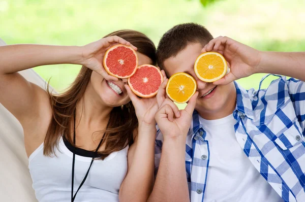 Pareja joven divirtiéndose con frutas — Foto de Stock