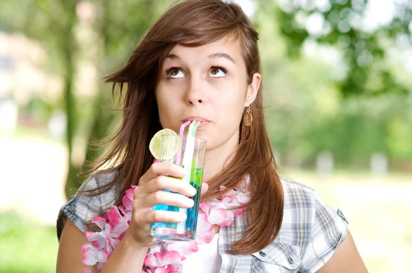 Молодая женщина пьет голубой коктейль курасао — стоковое фото