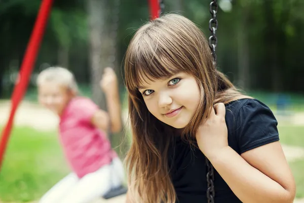 Kleines Mädchen lächelt auf Schaukel — Stockfoto