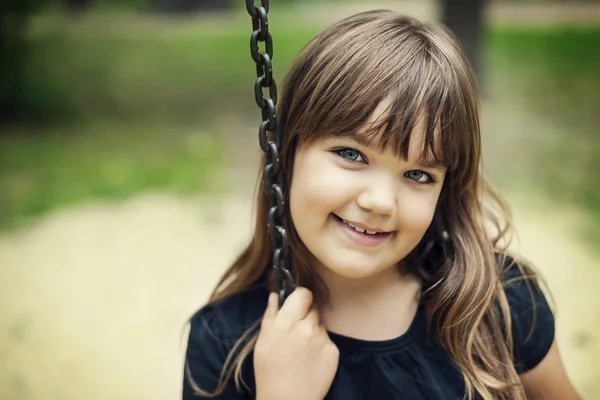 Portrait of smiling girl on swing — Stock Photo, Image