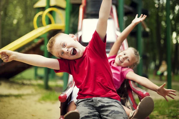 Two kids slide on playground — Stock Photo, Image