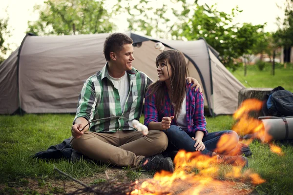 Couple près d'un feu de camp griller guimauve — Photo