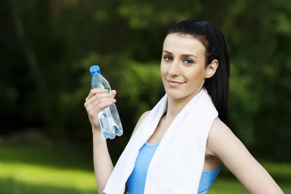 Jonge vrouw met fles water — Stockfoto