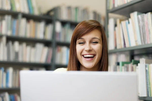 Uczeń korzysta z laptopa w bibliotece — Zdjęcie stockowe