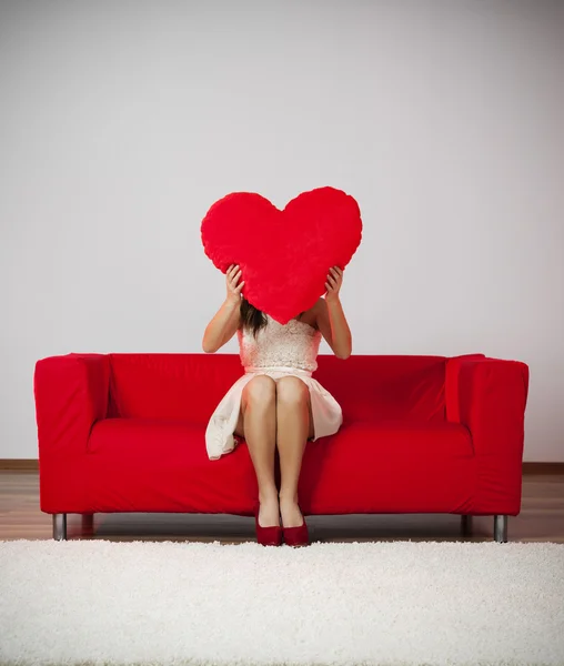 Mujer sosteniendo almohada en forma de corazón — Foto de Stock