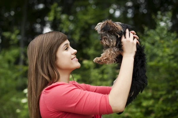 Mujer sonriente sosteniendo lindo cachorro — Foto de Stock