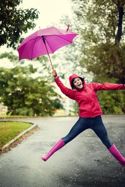 Ung kvinna under rosa paraply — Stockfoto