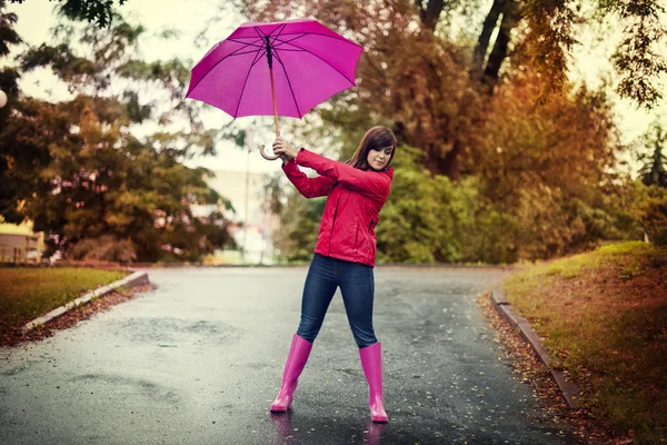 Mladá žena růžový deštník — Stock fotografie