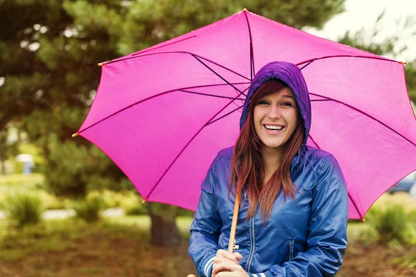 年轻女子在粉红色的雨伞下 — 图库照片