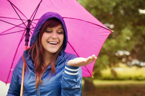 Jonge vrouw onder roze paraplu — Stockfoto