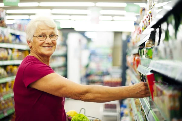 Seniorin im Supermarkt — Stockfoto