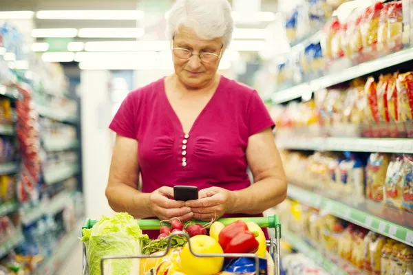 Seniorin im Supermarkt — Stockfoto