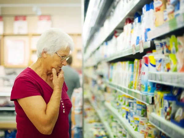 Senior vrouw in supermarkt — Stockfoto