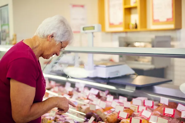 Senior vrouw in supermarkt — Stockfoto