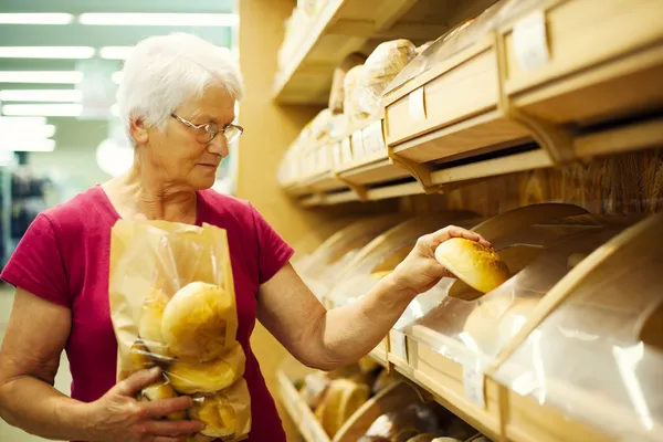 Senior vrouw in supermarkt — Stockfoto