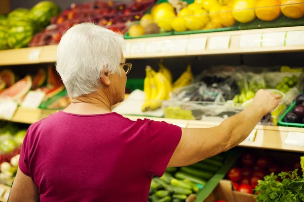 Senior vrouw in supermarkt — Stockfoto