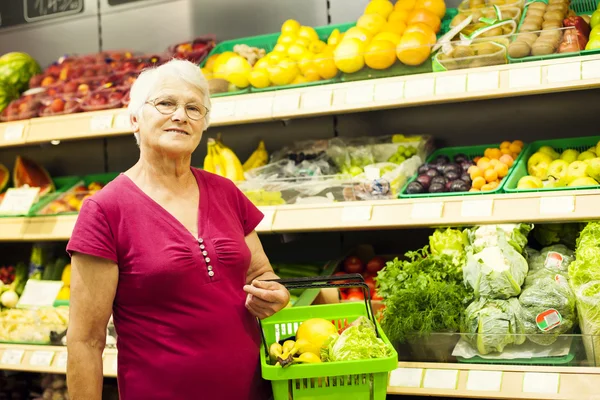 Senior vrouw in supermarkt — Stockfoto