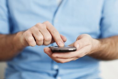 Adam cep telefonundan mesaj atıyor.