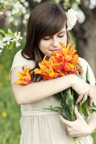 Woman enjoying the fragrance of flowers — Stock Photo, Image