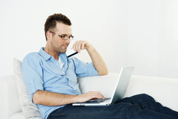 Homem usando cartão de crédito e laptop — Fotografia de Stock