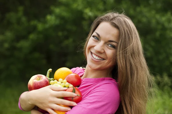 Mujer joven sosteniendo frutas y verduras —  Fotos de Stock