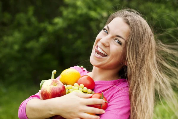 Mujer joven sosteniendo frutas y verduras — Foto de Stock