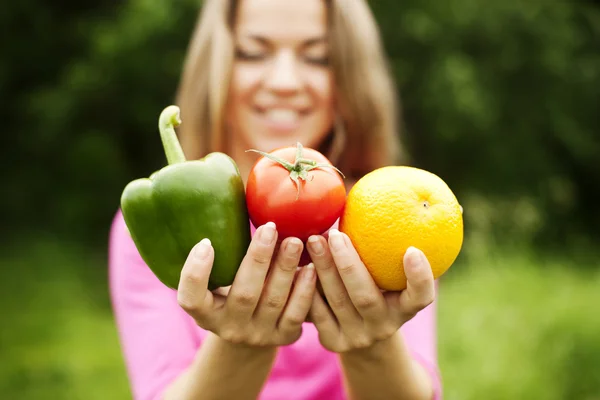 Giovane donna che tiene frutta e verdura — Foto Stock