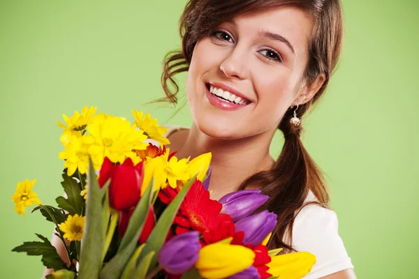 Glad ung kvinna med blommor — Stockfoto