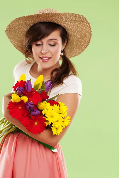 봄 꽃을 들고 밀 짚 모자를 착용 해 여자 — 스톡 사진
