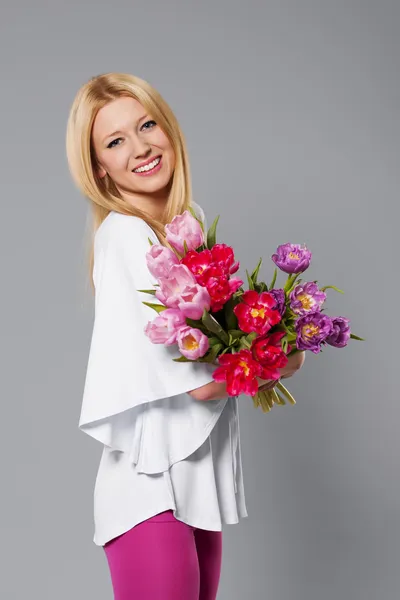 Smiling blonde woman with spring flowe — Stock Photo, Image