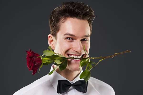 Uomo con una rosa rossa in bocca — Foto Stock